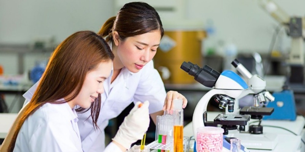Two women in lab coats working 
