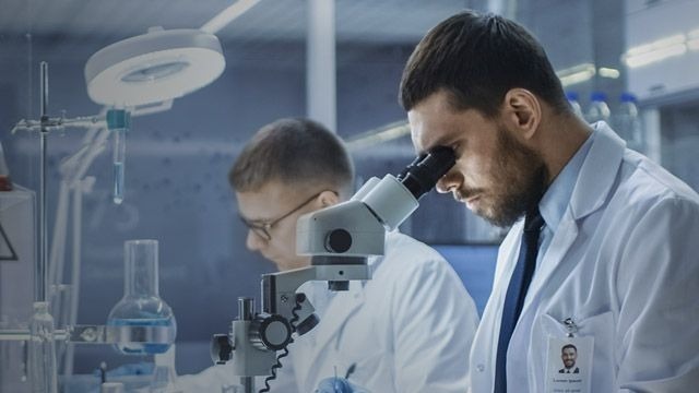 Lab technician working with microscope