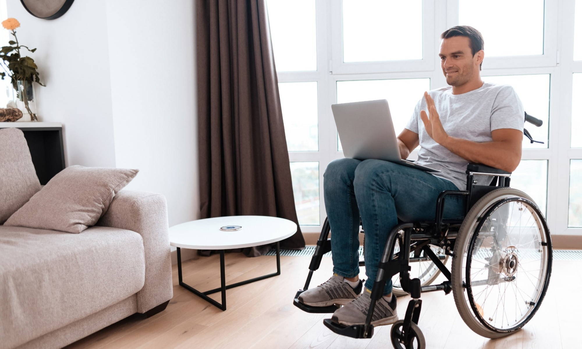 Man in wheelchair working from home with laptop