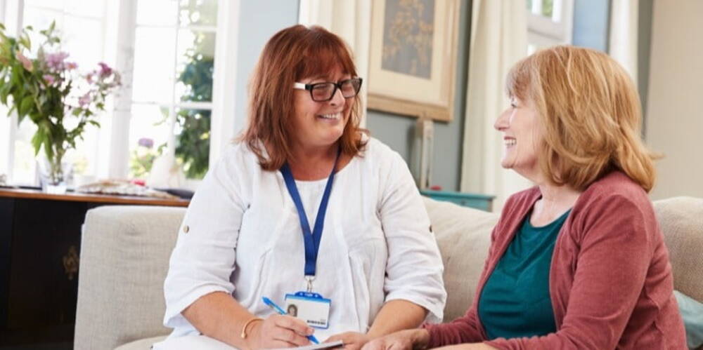 Social worker on sofa with elderly woman