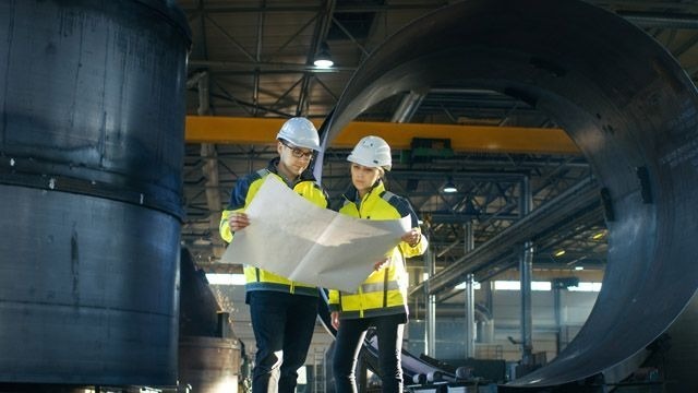 Employees in hard hats working on engineering project