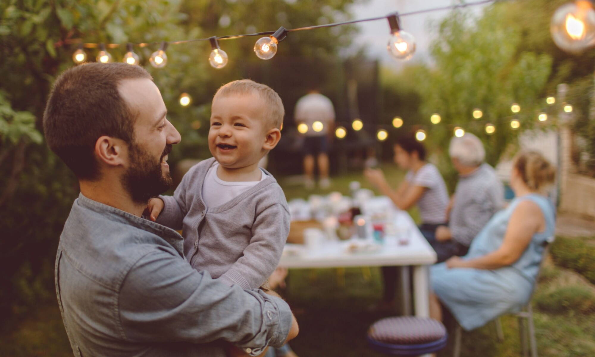 Happy dad smiling at son in garden