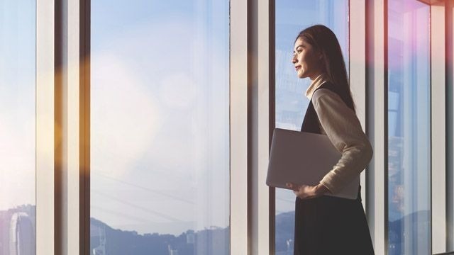 Female manager looking out of window thinking