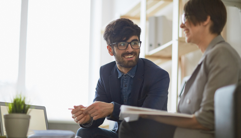 Happy man in casual suit talking to happy woman