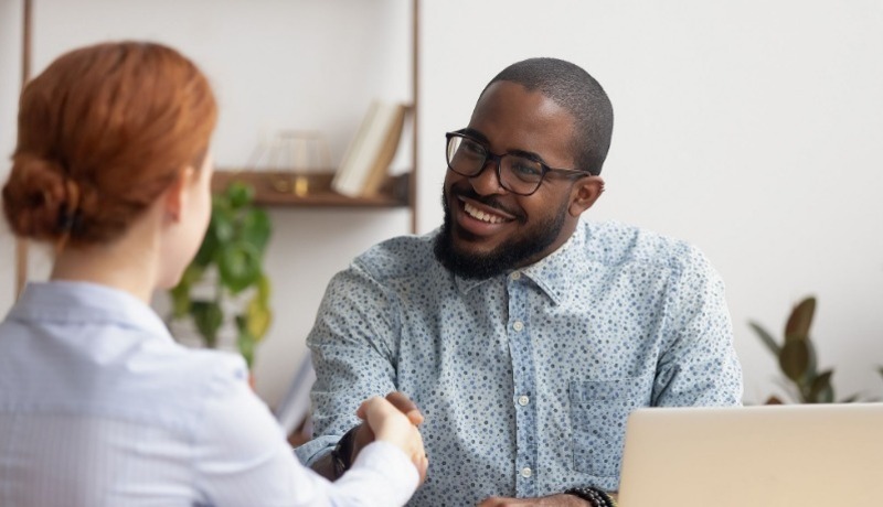 Young man with beard smiling and talking with woman